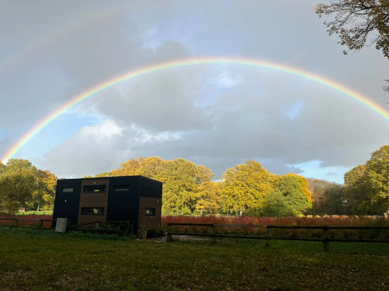 Regenbogen über einem kleinen Haus im Grünen