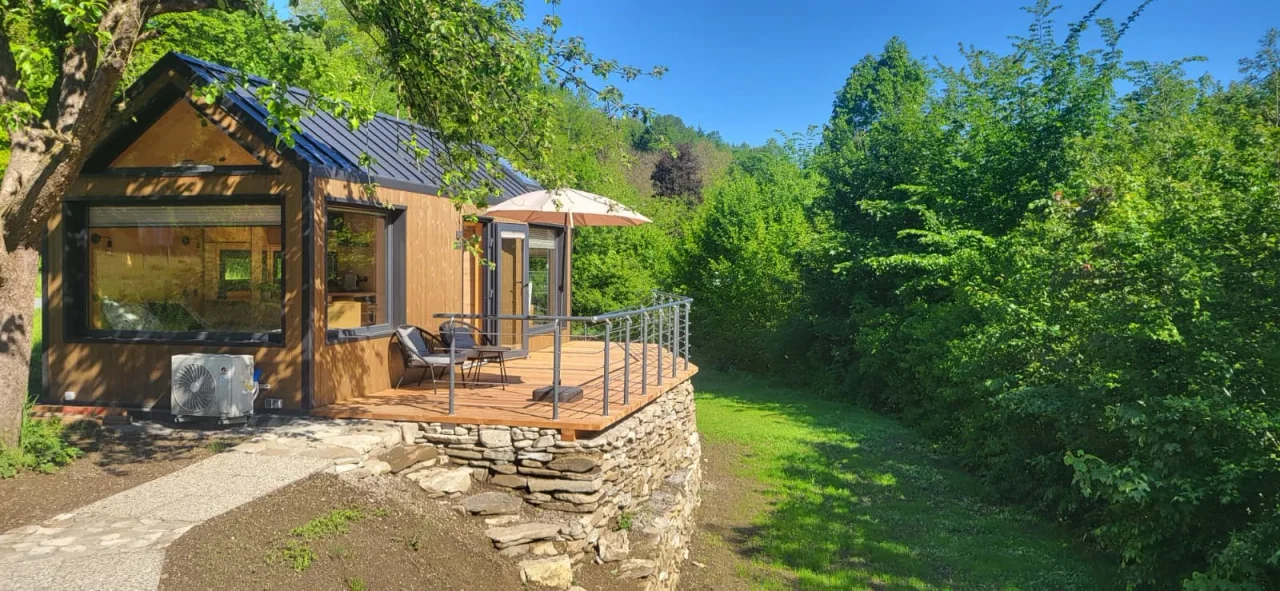 Tiny House mit Terrasse in einem grünen Garten im Magazin von Modulhaus Direkt